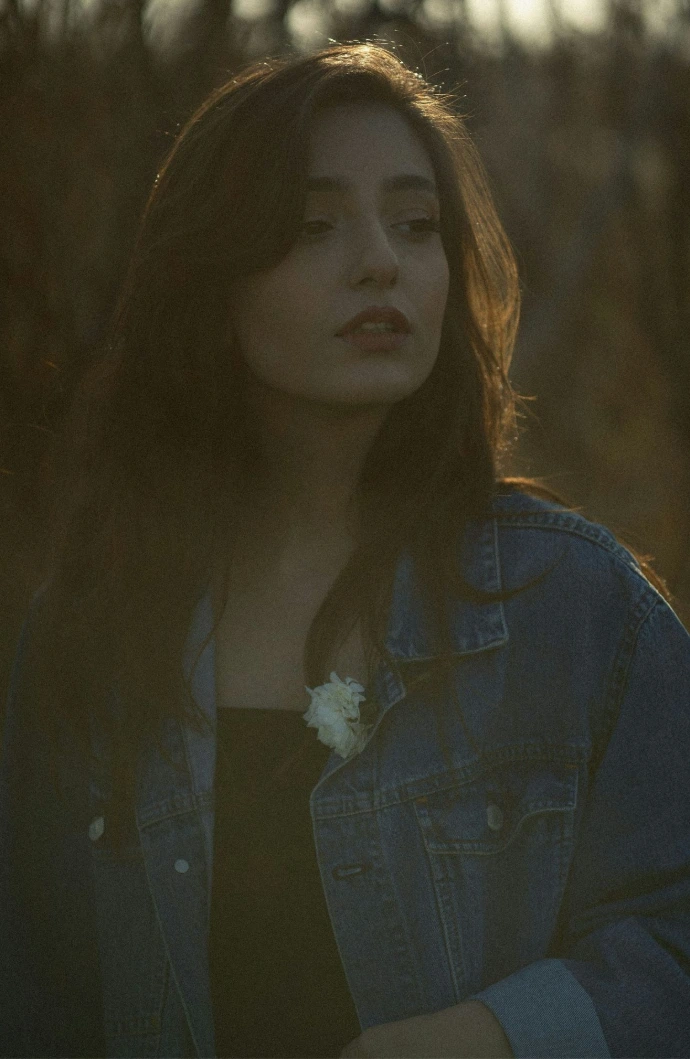 a woman with long hair wearing a jean jacket